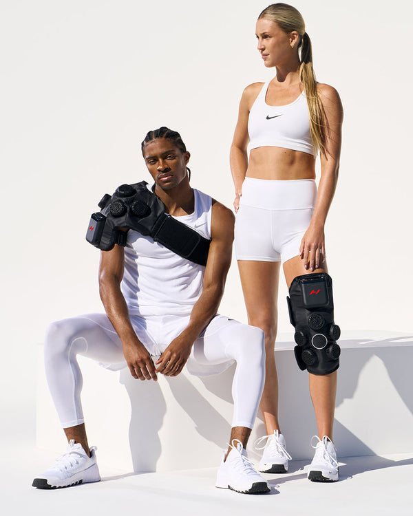 Two people wearing white Nike athletic gear with one wearing the Hyperice X 2 Shoulder, and one wearing the Hyperice X 2 Knee
